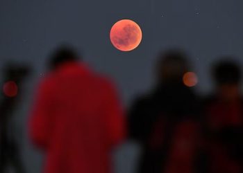 Хората се събират, за да гледат „кърваво лунно“ затъмнение в Мелбърн, Австралия, на 28 юли 2018 г. На 13-14 март 2025 г. наблюдателите на небето в цяла Северна Америка ще имат страхотна гледка, докато Луната става червена по време на пълно лунно затъмнение – първото видимо в региона от 2022 г. насам. © Уилям Уест, AFP/Getty Images