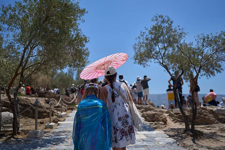Туристка с чадър, за да се предпази от слънцето близо до Акропола, Гърция/AP Photo/Petros Giannakouris