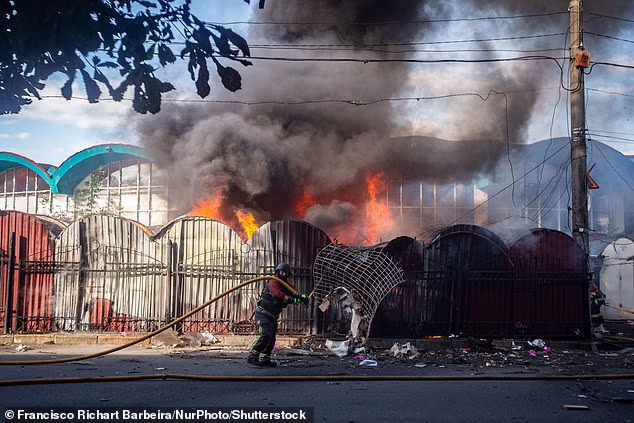 Е, вярвам, че украинската армия сега приема доброволци от почти навсякъде, от почти всяка възраст. Трябва. На снимката: пожарникар се опитва да потуши пожар на централния пазар в Суми, Украйна, причинен от експлозията на руски дрон на 15 август