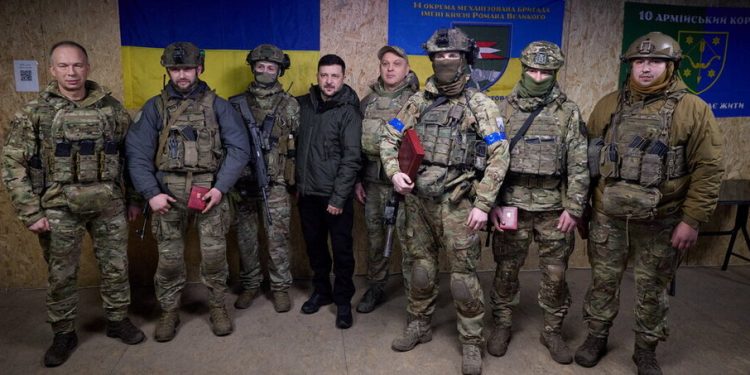 Пресслужба на украинския президент/Материал чрез REUTERS Украинският президент (в центъра) и главнокомандващият (вляво) позират с армейско поделение (Купянск, 12 декември 2025 г.)