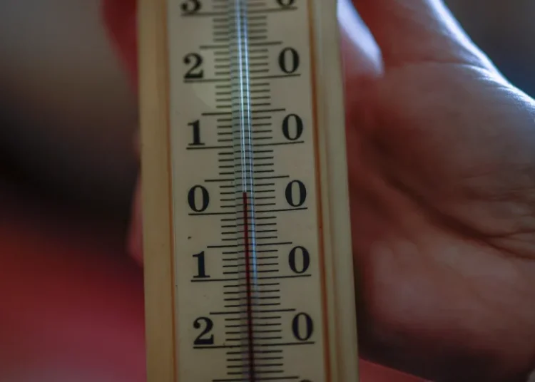 Юлия Давиденко показва термометър от само 3 градуса по Целзий (около 37 градуса по Фаренхайт) в апартамента на семейството си в Киев, който няма отопление или топла вода и страда от чести прекъсвания на електрозахранването (Alina Smutko/Reuters)