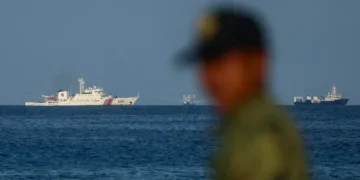 Филипински морски пехотинец наблюдава кораби на китайската брегова охрана край бреговете на остров Титу в контролираните от Манила спорни води в Южнокитайско море. 3 май 2026 г. Daniel Ceng / Anadolu / Getty