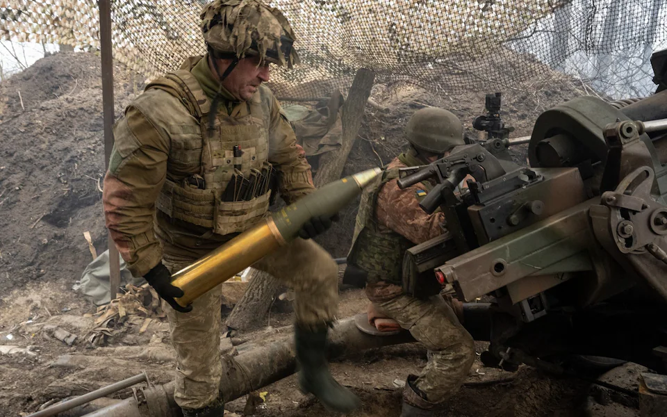 Украински войник зарежда оръдие, докато войници от 95-та бригада на украинската армия стрелят със 105-милиметрови артилерийски снаряди от британска гаубица L119 по руски позиции в посока Лиман на 18 февруари 2024 г. на неразкрито място в Украйна.