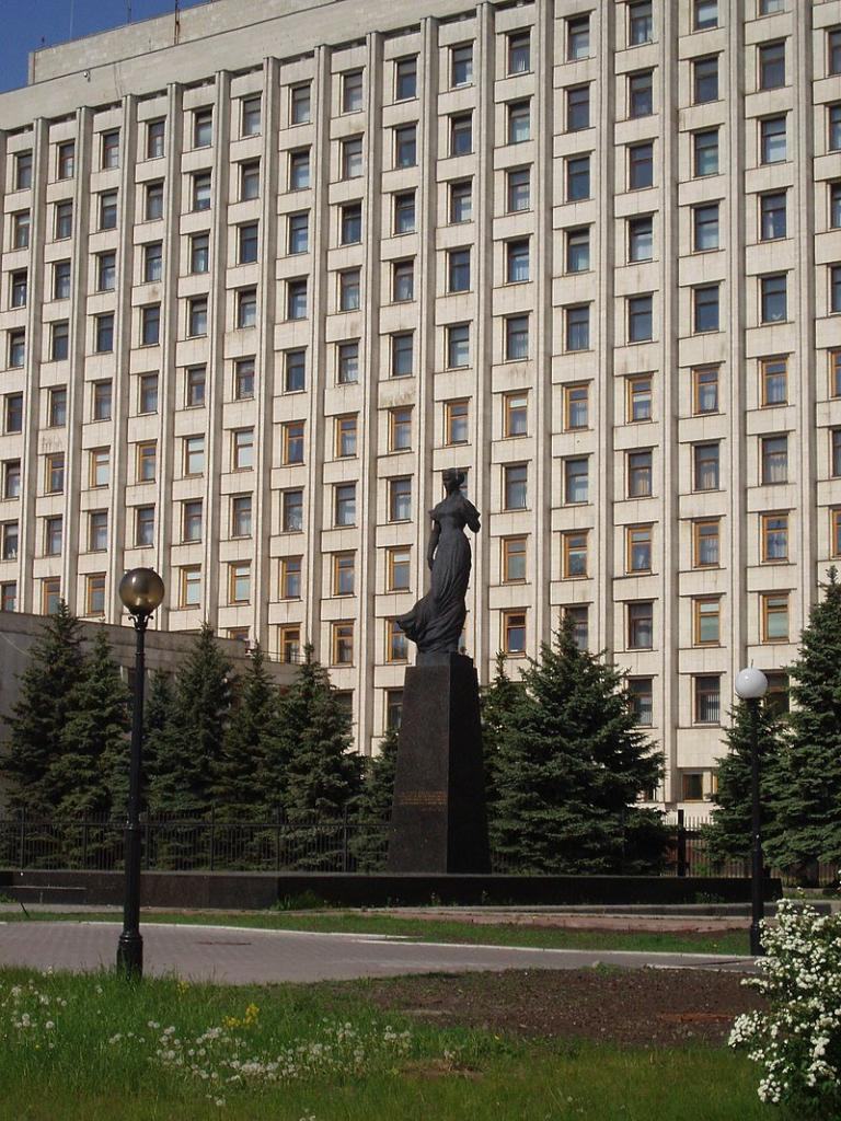 Паметник на Леся Украинка на фона на сградата на Централната избирателна комисия в Киев